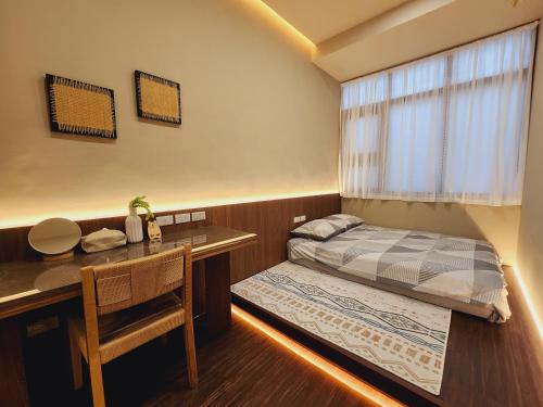 a small bedroom with a bed and a desk at Ran has to get up in Tainan