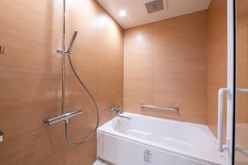 大阪的住宿－Welina Hotel Premier Osaka Namba，带淋浴和白色浴缸的浴室