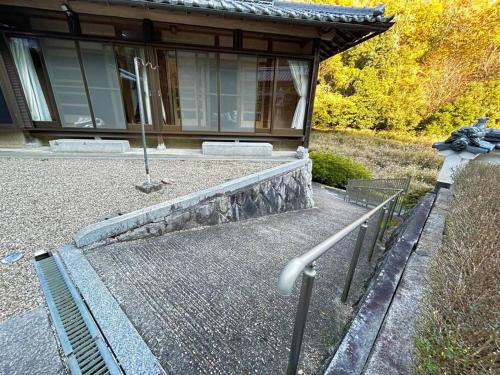 a house with a bench in front of a building at 福宿 奈良東大寺から車で約10分 近鉄奈良駅から車で約12分 in Ō-yagyūchō