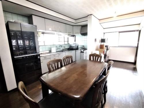 a kitchen with a wooden dining table and chairs at 福宿 奈良東大寺から車で約10分 近鉄奈良駅から車で約12分 in Ō-yagyūchō