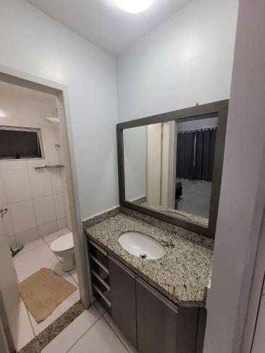 a bathroom with a sink and a mirror at Lagoa Flat Service RM Hopsedagem in Caldas Novas
