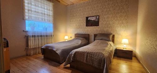 una camera con due letti e una finestra di Mansion on the river a Yuxarı Lǝgǝr