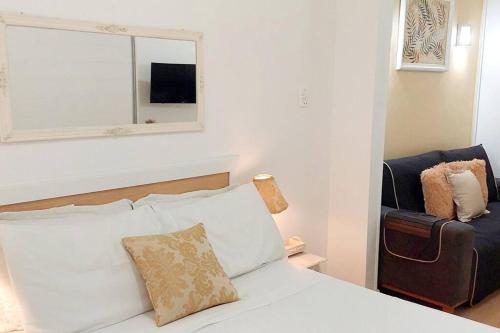 a bedroom with a bed with a mirror and a chair at Bem Localizado Botafogo in Rio de Janeiro