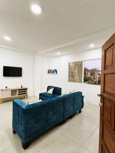 a blue couch in a living room with a tv at Sea Lion Suite 02 in Puerto Baquerizo Moreno