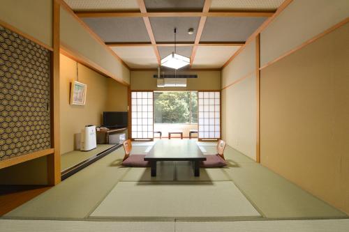 Ooedo Onsen Monogatari Hotel Kinugawa Gyoen في نيكو: غرفة طعام مع طاولة وكراسي