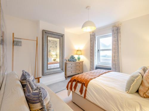 a bedroom with a bed and a mirror and a window at Big Skies in Lowestoft