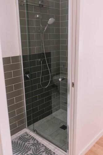 a shower with a glass door in a bathroom at TreeTops Tamborine Mountain in Mount Tamborine
