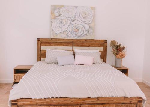 a bedroom with a large bed with two pillows at TreeTops Tamborine Mountain in Mount Tamborine