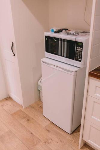 a microwave on top of a refrigerator in a kitchen at TreeTops Tamborine Mountain in Mount Tamborine