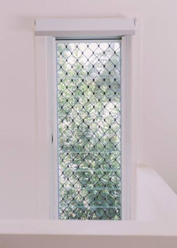 a window in a white door with a fence at TreeTops Tamborine Mountain in Mount Tamborine