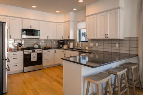 a kitchen with white cabinets and black counter tops at Aspects Big Sky in Big Sky