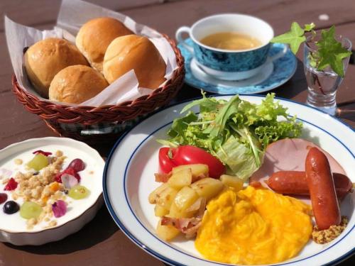 Kiyosatokogen Country Inn The Classic في هوكوتو: طاولة مع أطباق من الطعام وكوب من الشاي