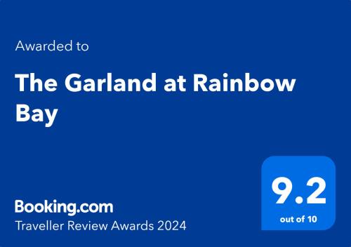 um sinal azul com o texto o jardim na baía do arco-íris em The Garland at Rainbow Bay em Gold Coast