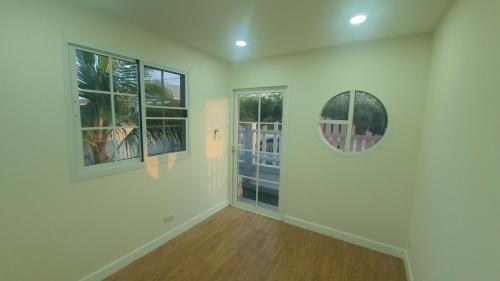 a room with two windows and a mirror on the wall at Family POOL VILLA CHAAM in Cha Am