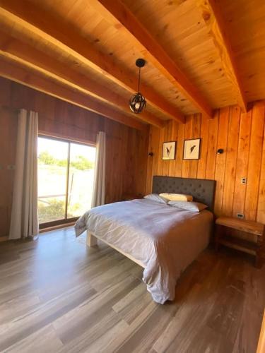 una camera da letto con letto in una camera in legno di Cómodas y acogedoras cabañas a Huépil
