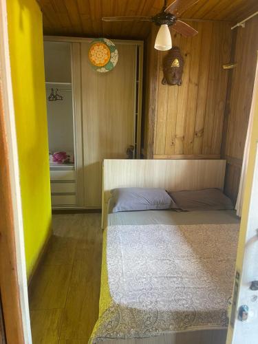 a room with a bed and a yellow wall at Pousada - Quintal do Rosa in Praia do Rosa