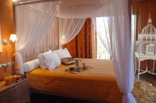 a bedroom with a canopy bed with a tray on it at Olympic Fashion Hotels in Athens