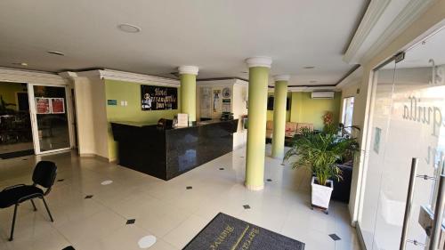 a lobby of a restaurant with columns and a counter at Hotel Barranquilla Inn in Barranquilla