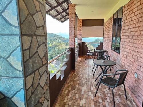 a balcony with tables and chairs and a view at Tekoma Resort Cameron Highlands in Tanah Rata