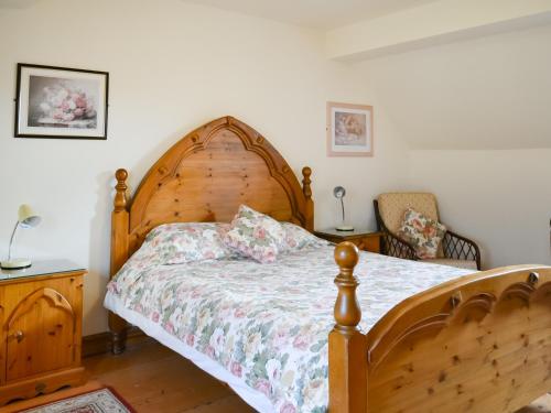 1 dormitorio con cama de madera y cabecero de madera en Daisy Cottage - Uk46262, en Tetney