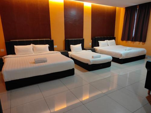 Duas camas num quarto com paredes amarelas e laranja em Tekoma Resort Cameron Highlands em Tanah Rata