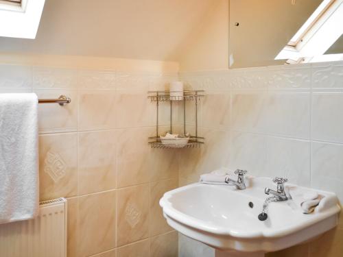 a white bathroom with a sink and a mirror at Daisy Cottage - Uk46262 in Tetney