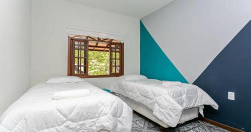 1 dormitorio con 2 camas y ventana en Casa no Campeche, en Florianópolis