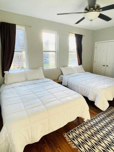 a bedroom with two beds and a ceiling fan at SPACIOUS & MODERN 3 BR HOME WI-Fi FREE PARKING in Chicago