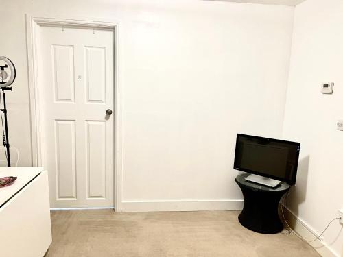 un televisor sentado en un taburete en una habitación en Two bedroom flat with a sofa bed living room en Londres