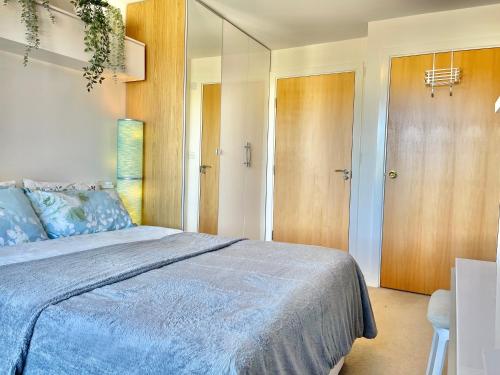 1 dormitorio con 1 cama grande con manta azul en Two bedroom flat with a sofa bed living room, en Londres