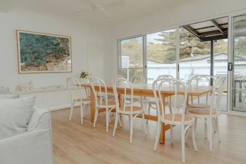 Un comedor con mesa y sillas de madera. en The Cove Jervis Bay, en Jervis Bay Village