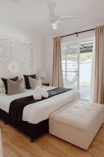 a bedroom with a large bed and a large window at The Cove Jervis Bay in Jervis Bay Village