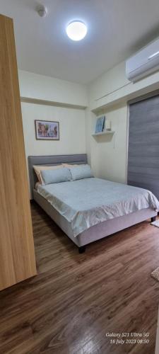 馬尼拉的住宿－A cozy 2 bedroom condo in Metro，一间卧室配有一张床,铺有木地板