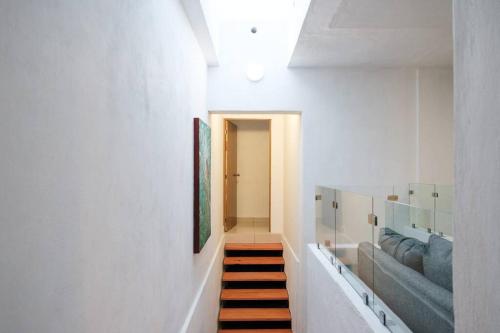 un pasillo con una escalera que conduce a una habitación en Colomos, 5 BR w/AC king bed, backyard & parking., en Guadalajara