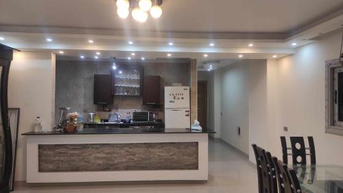 a kitchen with a counter and a refrigerator at Comfy Luxurious Apartment in Central Location in Mansheyet El Bakry East Cairo in Cairo