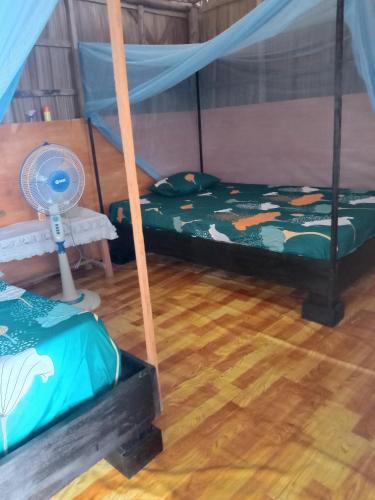 a room with two beds and a fan at Amfriwen Homestay in Yennanas Besir