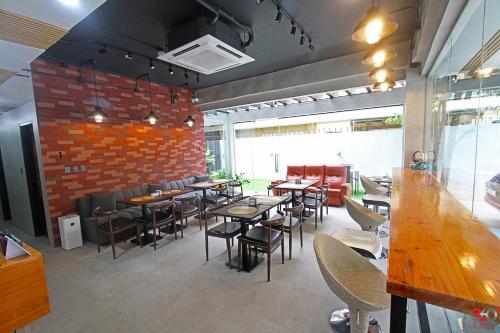 un restaurante con mesas y sillas y una pared de ladrillo en Kasa Boutique Hotel en Cebú