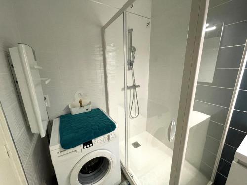 une machine à laver dans une salle de bain avec douche dans l'établissement Magnifique appart rénové 2 chambres, face à la mer - 3 étoiles, garage privé, proche plage et commerces - FR-1-323-329, à Saint-Jean-de-Monts