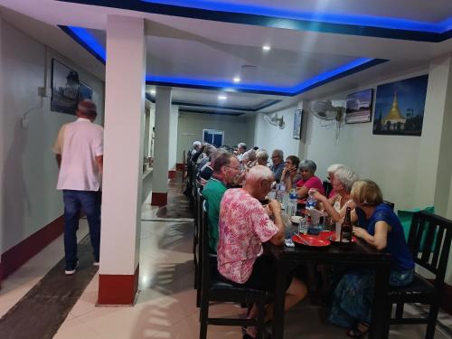 grupa ludzi siedzących przy stole w restauracji w obiekcie HOTEL GOLDEN BUDDHA w mieście Rummindei