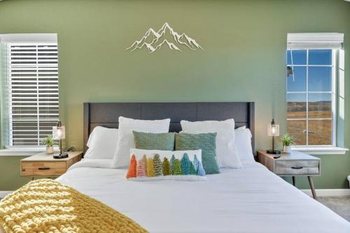1 dormitorio con 1 cama blanca grande con almohadas coloridas en Mtn View Oasis: 5bd - Movie/Game - Golden Tee, en Superior