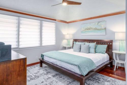 um quarto com uma cama, uma televisão e janelas em Spacious Beachfront — Sleeps 6 — Ocean Views em Kihei