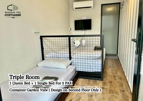 een kleine kamer met een bed met een koe in een kooi bij Reserve The Cozytainer in Taiping