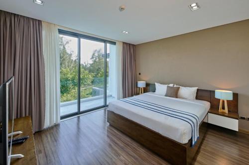 een slaapkamer met een groot bed en een groot raam bij The Point Villa Da Nang in Da Nang