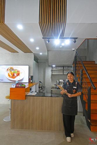 a woman standing next to a counter in a restaurant at Kasa Boutique Hotel in Cebu City