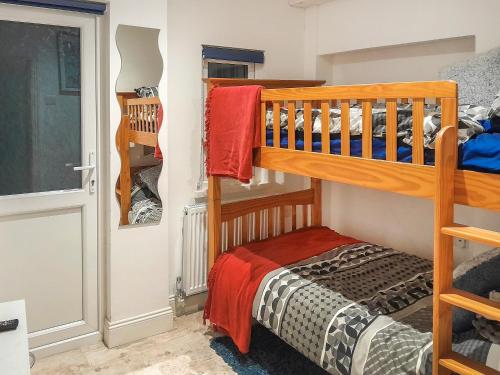 a small bedroom with a bunk bed and a door at Harbour Way in Ilfracombe