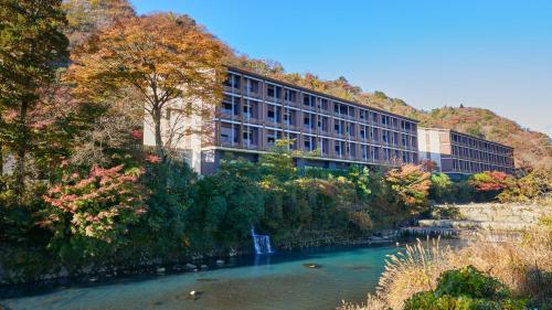 a building next to a river with trees at Hotel Indigo Hakone Gora by IHG in Hakone