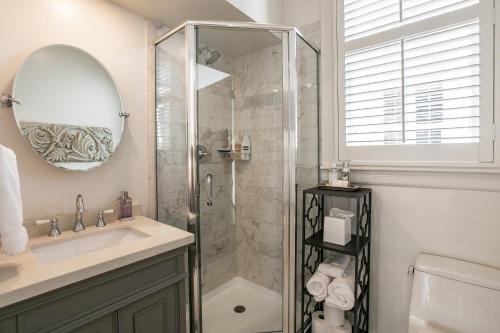 uma casa de banho com um chuveiro, um lavatório e um espelho. em Pacific Heights Grand Elegant Studio em São Francisco