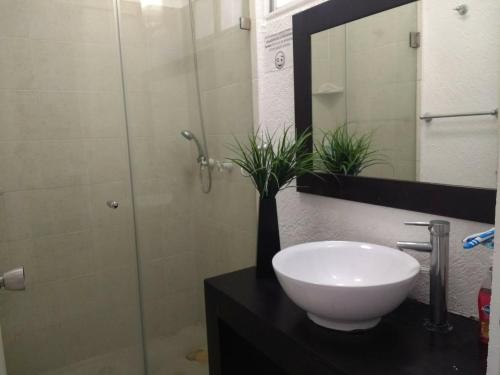 La salle de bains est pourvue d'un lavabo et d'une douche en verre. dans l'établissement Penthouse Acapulco Diamante Markis K 31, à Acapulco