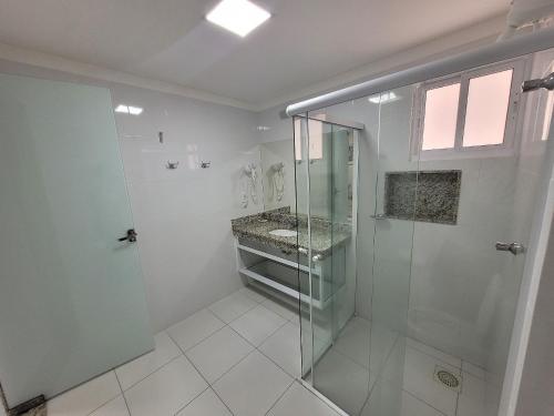ein Bad mit einer Dusche und einem Waschbecken in der Unterkunft Piazza diRoma RM Hopedagem com Acesso Acqua Park/Splash in Caldas Novas
