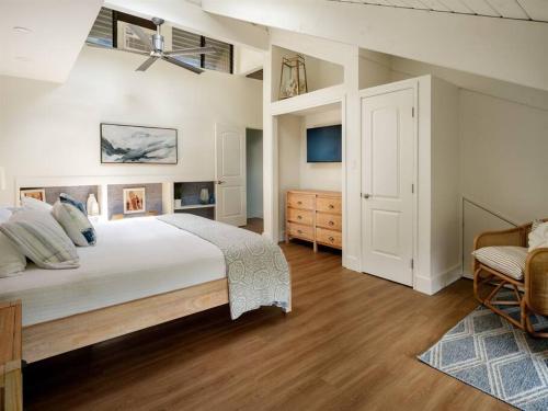 a bedroom with a large bed and a dresser at Newly Remodeled Luxury Condo — Sleeps 7 in Kihei